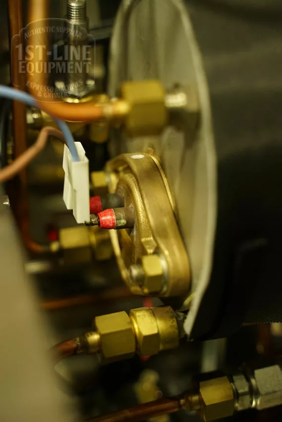 Close-up of brass boiler connections, wiring, and fittings inside the Elektra Verve Dual Boiler Espresso Machine, highlighting electrical terminals and copper pipes secured with nuts and connectors. © 2025 1st-line.com