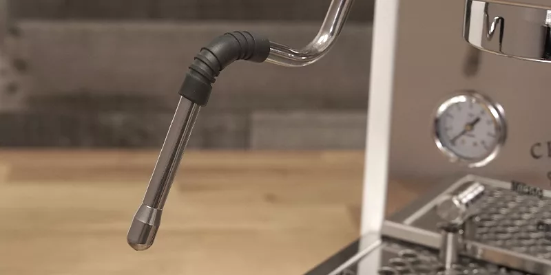 A close-up of the stainless steel steam wand on the Bezzera Crema DE HX Espresso Machine, with a pressure gauge and drip tray in the background. © 2025 1st-line.com