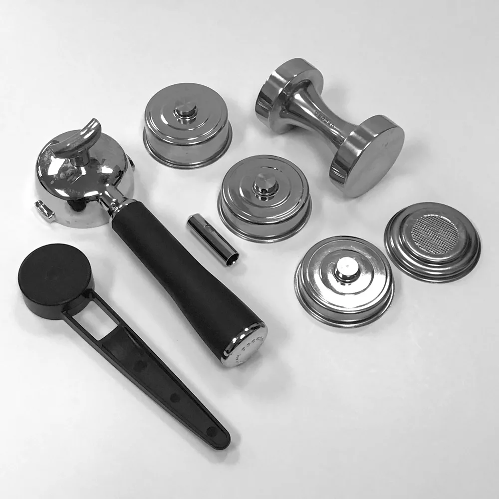 A set of espresso machine accessories, including a portafilter with a black handle, filter baskets, a metal tamper, and a dosing ring, all arranged on a white surface. © 2025 1st-line.com