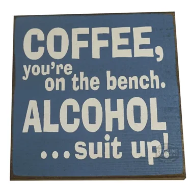 Add some humor to your space with the Coffee, youre on the bench. Alcohol...suit up! sign—a blue wooden board featuring bold white lettering. © 2025 1st-line.com