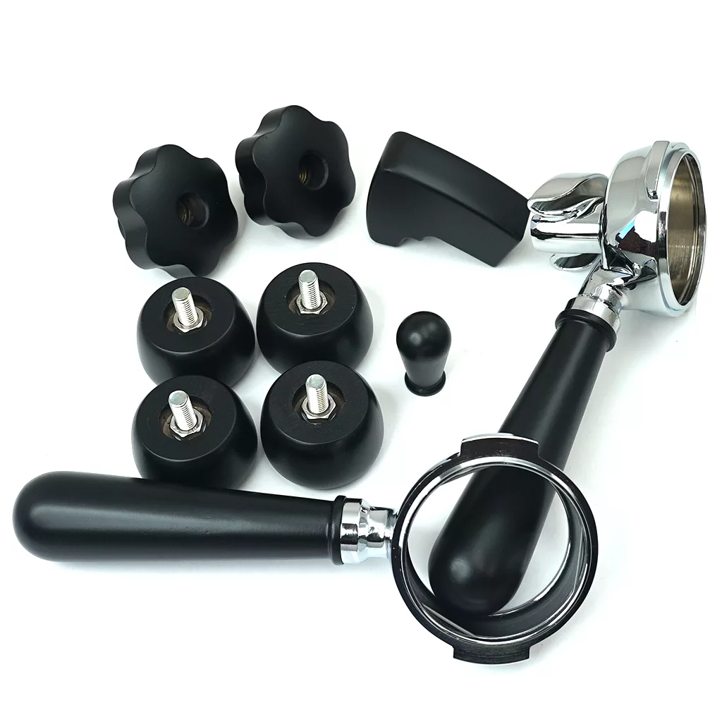 Assorted black and chrome espresso machine parts, including Lelit accessories such as portafilters with handles, knob attachments, the Lelit PLA2201 Black Wood Kit, and more components are displayed on a white surface. © 2025 1st-line.com