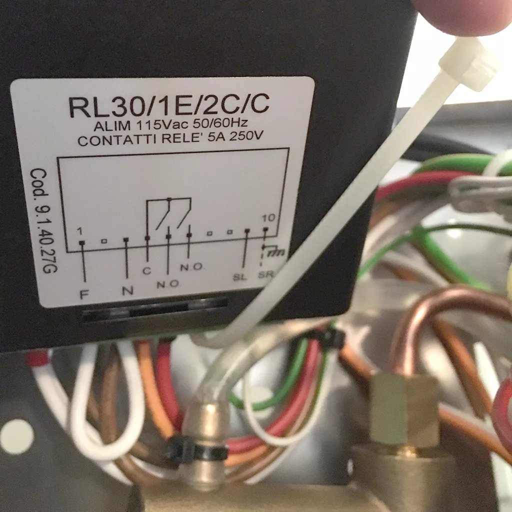 Close-up of an electrical component labeled RL30/1E/2C/C on a VBM Super HX espresso machine, with wiring diagram, specs (115Vac, 50/60Hz, 5A 250V), and multiple colored wires connected to pipes and fittings in the background. © 2025 1st-line.com