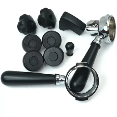 Lelit PLA2201 Black Wood Kit parts—including two black portafilter handles, four rubber feet, two knob handles, a small black plug, and a plastic part—are arranged on a white background. © 2025 1st-line.com