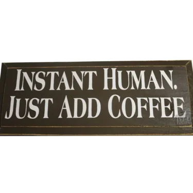 The Instant Human Just Add Coffee Sign by 1st-line Equipment is a brown rectangular sign with white text—a fun décor piece for coffee enthusiasts. © 2025 1st-line.com