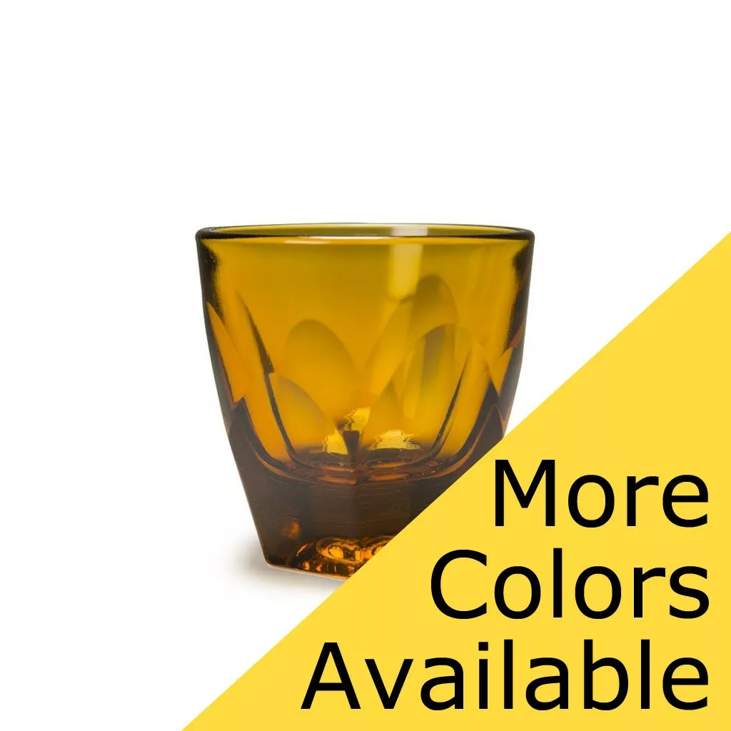 Amber-colored DISCONTINUED notNeutral VERO Cappuccino Glass - 6 oz with a faceted design, shown on a white background. A yellow banner displays “More Colors Available” in bold black text. © 2025 1st-line.com
