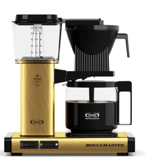 The DISCONTINUED Technivorm Moccamaster KBG Glass Carafe Coffee Brewer in gold features a left glass water reservoir, center black brew basket, and right glass carafe with coffee, all on a matching gold base. © 2025 1st-line.com