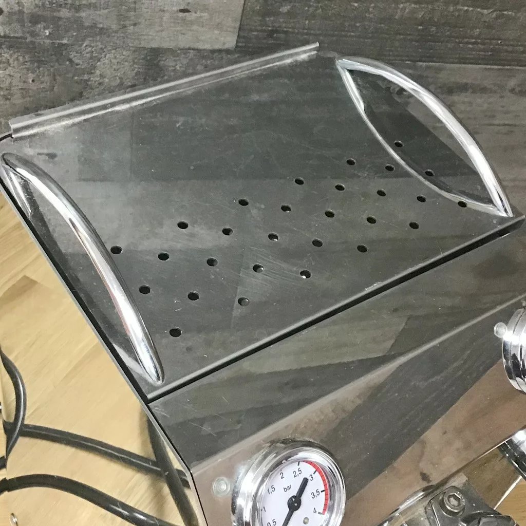 A close-up of the SOLD SIDEWALK SALE VBM Domobar Junior HX Espresso Machine shows its perforated metal warming tray and front pressure gauge—ideal for your next Sidewalk Sale display. © 2025 1st-line.com