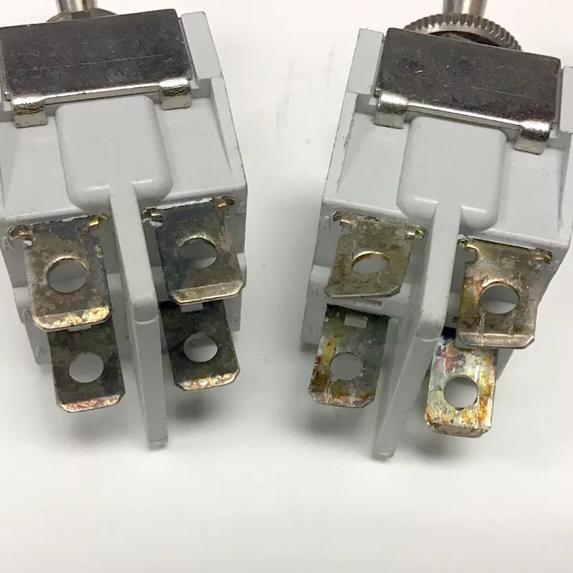 Close-up of two Isomac 000234 Power Switches, each with four slightly tarnished metal terminals, displayed side by side on a white background. © 2025 1st-line.com