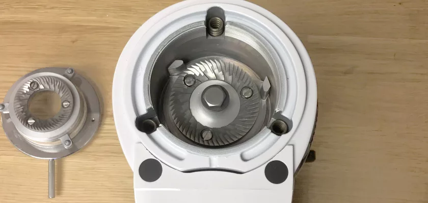 Top view of a DISCONTINUED Fiorenzato F4 Nano V2 Espresso Coffee Grinder with exposed metal burrs and mounting screws, plus a detached burr set displayed on a wooden surface. © 2025 1st-line.com