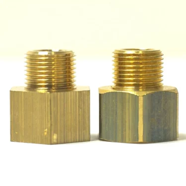 Two brass 1st-line Reducer 1/2F X 3/8M fittings with male threads stand upright on a white surface. They feature a shiny finish and visible machining marks against a pale background. © 2025 1st-line.com