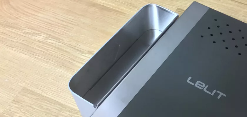 Close-up of a Lelit espresso machine with the Lelit PLA360M Knock Box Drawer w/ Cloth & Brush on a light wooden surface, highlighting its drip tray and bold LELIT logo—an essential coffee accessory. © 2025 1st-line.com