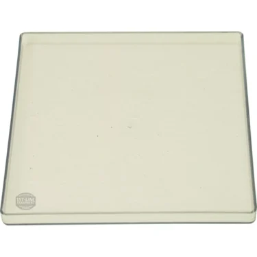 The Eureka 2311.0050 Bean Hopper Lid is a square, transparent glass plate with slightly raised edges—perfect as a replacement part. © 2025 1st-line.com