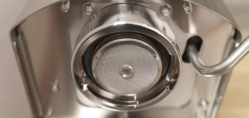 Close-up of the Bezzera New Hobby Espresso Machine group head, highlighting the polished steel shower screen and portafilter mount—ideal for anyone delving into specialty coffee. © 2025 1st-line.com