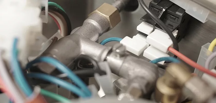 Close-up of the Bezzera New Hobby Espresso Machines internal components, including metal pipes, connectors, electrical wires, and plastic fittings—all clean and organized for those starting their coffee-making journey. © 2025 1st-line.com