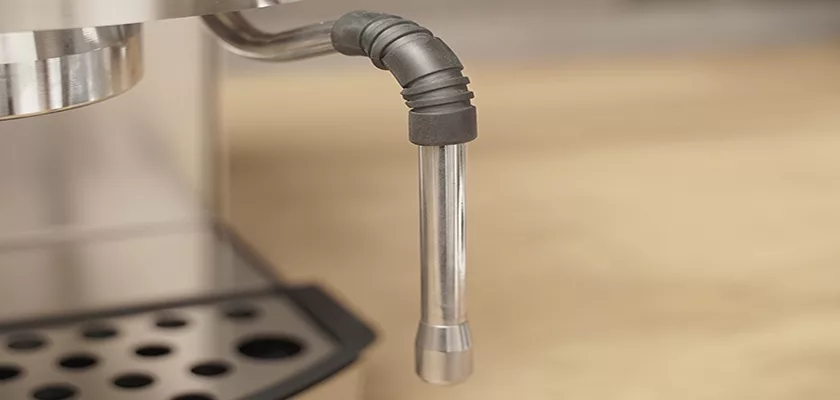 Close-up of the stainless steel steam wand on the Bezzera New Hobby Espresso Machine, with a drip tray featuring circular holes below—ideal for those starting their home coffee journey. The background is softly blurred. © 2025 1st-line.com