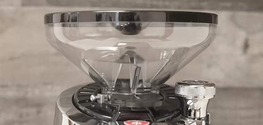 Close-up of the DISCONTINUED Eureka Olympus 75E High Speed Espresso Coffee Grinder with titanium burrs, large transparent hopper, and silver body, shown against a neutral background. © 2025 1st-line.com