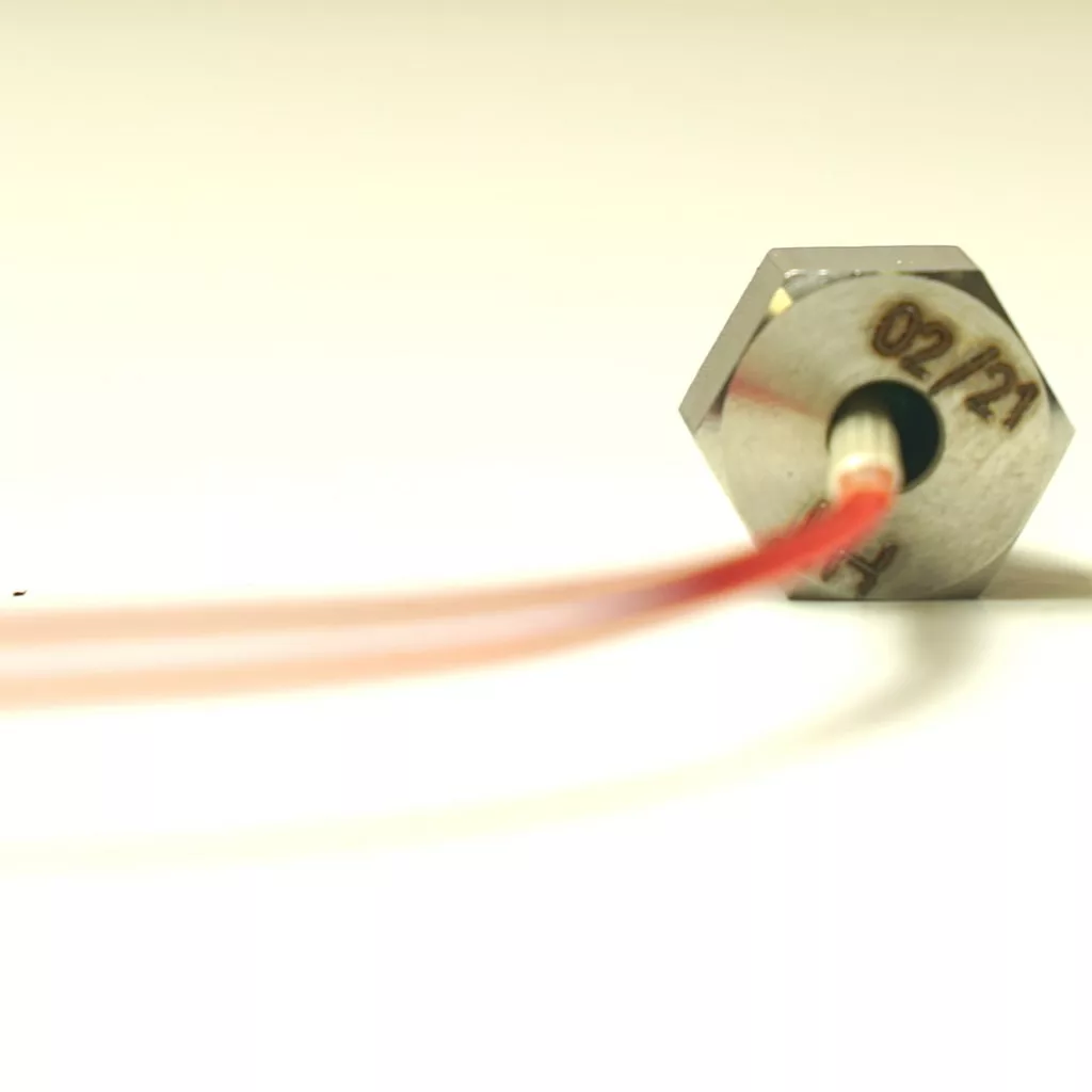 Close-up of a hexagonal metal Lelit 9600092 Temperature Probe / PID Sensor marked 02/21, attached to a red wire extending into the foreground, set against a light background. © 2025 1st-line.com