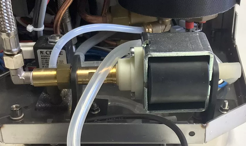 Close-up of the VBM Junior Digital HX Espresso Machine w/ Flow Control’s internal components, showing wires, tubes, metal parts, and a solenoid valve to highlight its advanced flow control and precise mechanical features. © 2025 1st-line.com