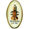 The Bezzera 9940201 Pin features an oval design with a vintage espresso machine illustration and BEZZERA Dal 1901 text on a cream background, finished with a thin gold rim. © 2025 1st-line.com