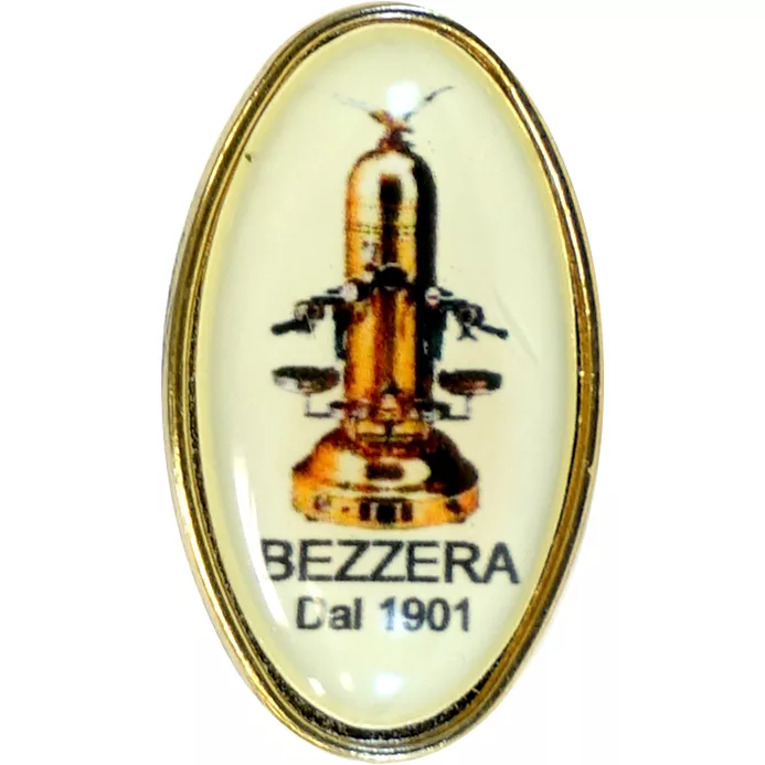The Bezzera 9940201 Pin features an oval design with a vintage espresso machine illustration and BEZZERA Dal 1901 text on a cream background, finished with a thin gold rim. © 2025 1st-line.com