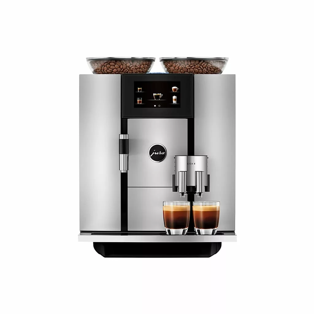 A modern silver DISCONTINUED Jura GIGA 6 (NAA) Automatic Espresso Machine with two coffee bean containers, digital display, and two espresso glasses under the dual spouts, shown against a white background. © 2025 1st-line.com