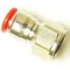 A close-up of the V.7522 Straight Female Fitting, a push-to-connect pneumatic fitting with a hexagonal nut and red plastic release ring on one end, shown against a white background. © 2025 1st-line.com