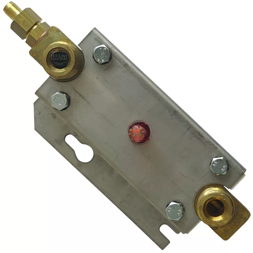 The FUTURMAT MODERN COMPLETE LEVEL GAUGE is a rectangular metal component with four bolts, brass fittings at each end, and a central circular window, used for monitoring fluid levels in mechanical or plumbing systems. © 2025 1st-line.com