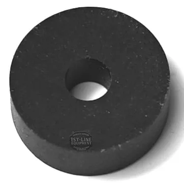 A CA...7 TAP RUBBER GASKET, black, round, and flat with a central hole, made of solid material, is shown at an angle against a white background. © 2025 1st-line.com