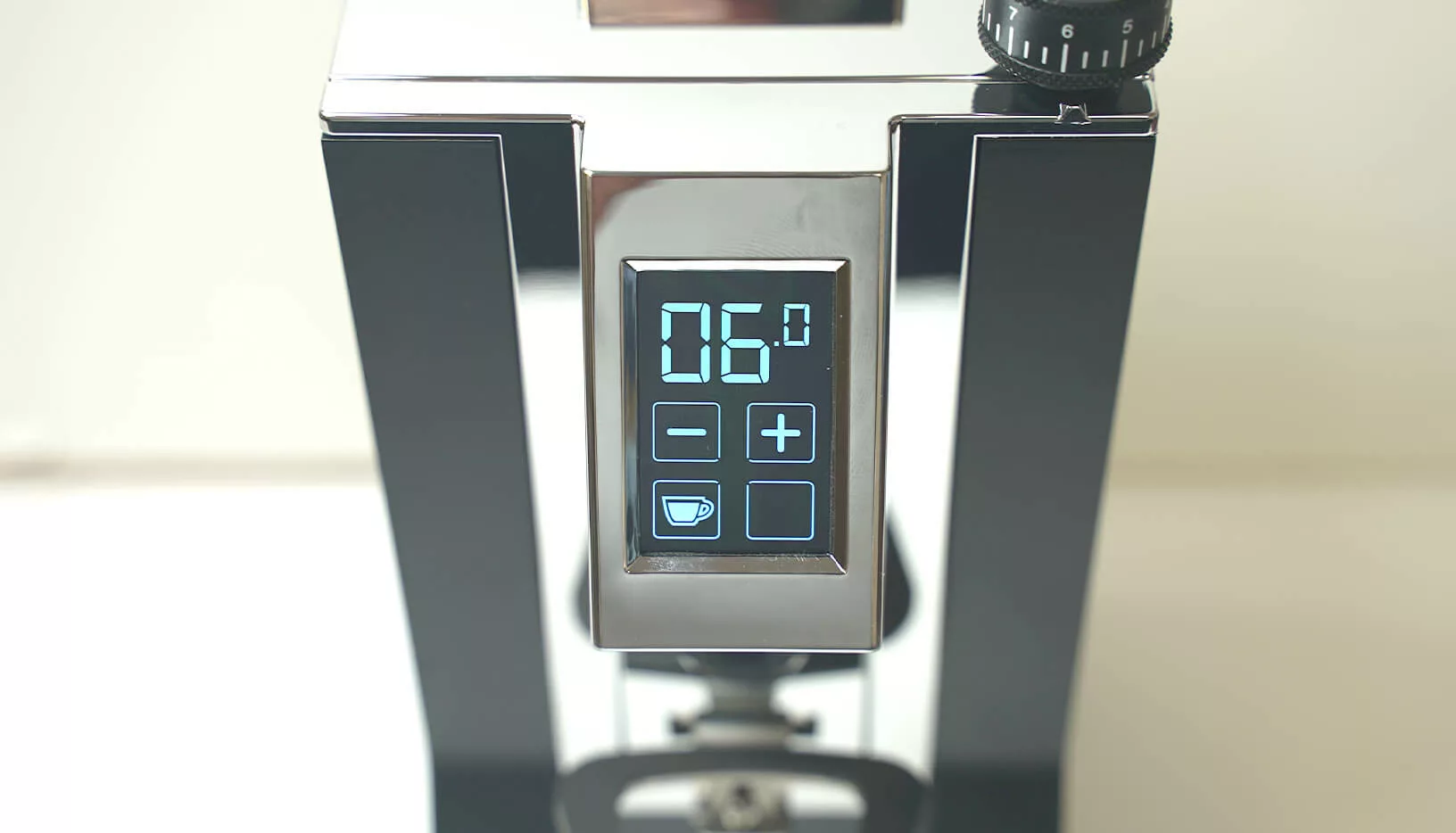 Close-up of the Eureka Oro Mignon XL Espresso Coffee Grinders digital display showing 06.0, with illuminated touch buttons (coffee cup, plus, and others), and a sleek modern metallic design. © 2025 1st-line.com