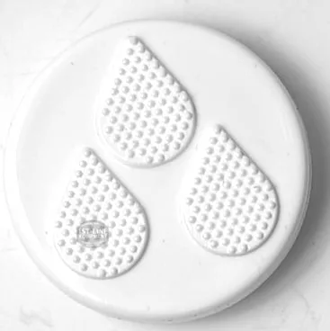 The F..472 STEAM HANDLE CAP is a round, white cap with three raised, textured teardrop shapes arranged in a triangle on its surface, shown against a light marbled background. © 2025 1st-line.com