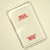 A clear rectangular plastic Rancilio Level Mask 90x50 mm, featuring red underlined MAX and MIN markings, is shown on a light surface, likely serving as a gauge or indicator cover. © 2025 1st-line.com