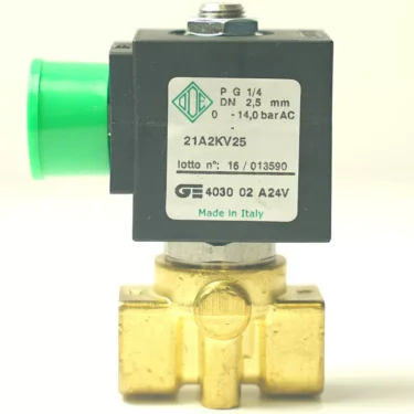 A close-up of a V.1467 24VAC 8W 1/4x1/4 ODE solenoid valve in brass and black, with a green plastic fitting and labels in Italian and English showing specs like 2-way, Made in Italy, and model number. © 2025 1st-line.com
