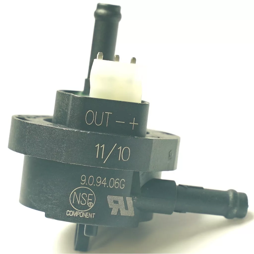 A close-up of the V.4239 PUSH SWITCH - GREY, a black electronic sensor or valve with two pipe connectors, labeled OUT - + 11/10 and NSF, RU certification marks; three metal prongs and a grey push switch are on top. © 2025 1st-line.com