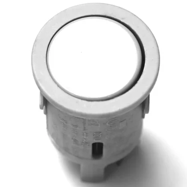 A close-up of the V.4239 PUSH SWITCH - GREY, featuring a round design with a flat white top, viewed from above on a white background. © 2025 1st-line.com