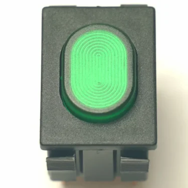 A close-up of the V.4291 GREEN SWITCH, a rectangular black and green switch with an oval button displaying a concentric pattern, potentially tactile or illuminated. © 2025 1st-line.com