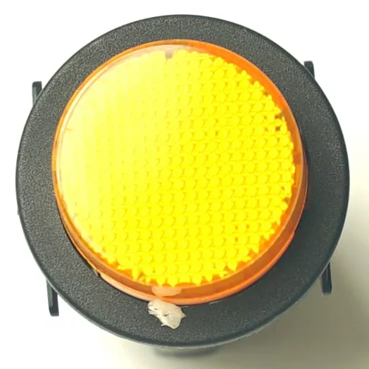 A close-up of the V.4331 YELLOW MOMENTARY PUSH SWITCH, a round pedestrian crossing button with a textured yellow surface on a black base. A small piece of white debris is visible near the bottom. © 2025 1st-line.com