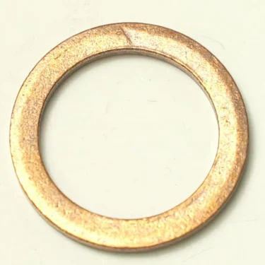 A close-up of the W..154 COPPER GASKET 24x18x2 mm washer, a flat circular copper gasket with a central hole, displayed against a light background. © 2025 1st-line.com
