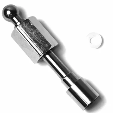 A shiny metal mechanical part with a hexagonal center, a ball-shaped end, and a cylindrical end lies on a white surface beside an SM.130 PTFE GASKET 14.5x10.5x4.5mm. © 2025 1st-line.com