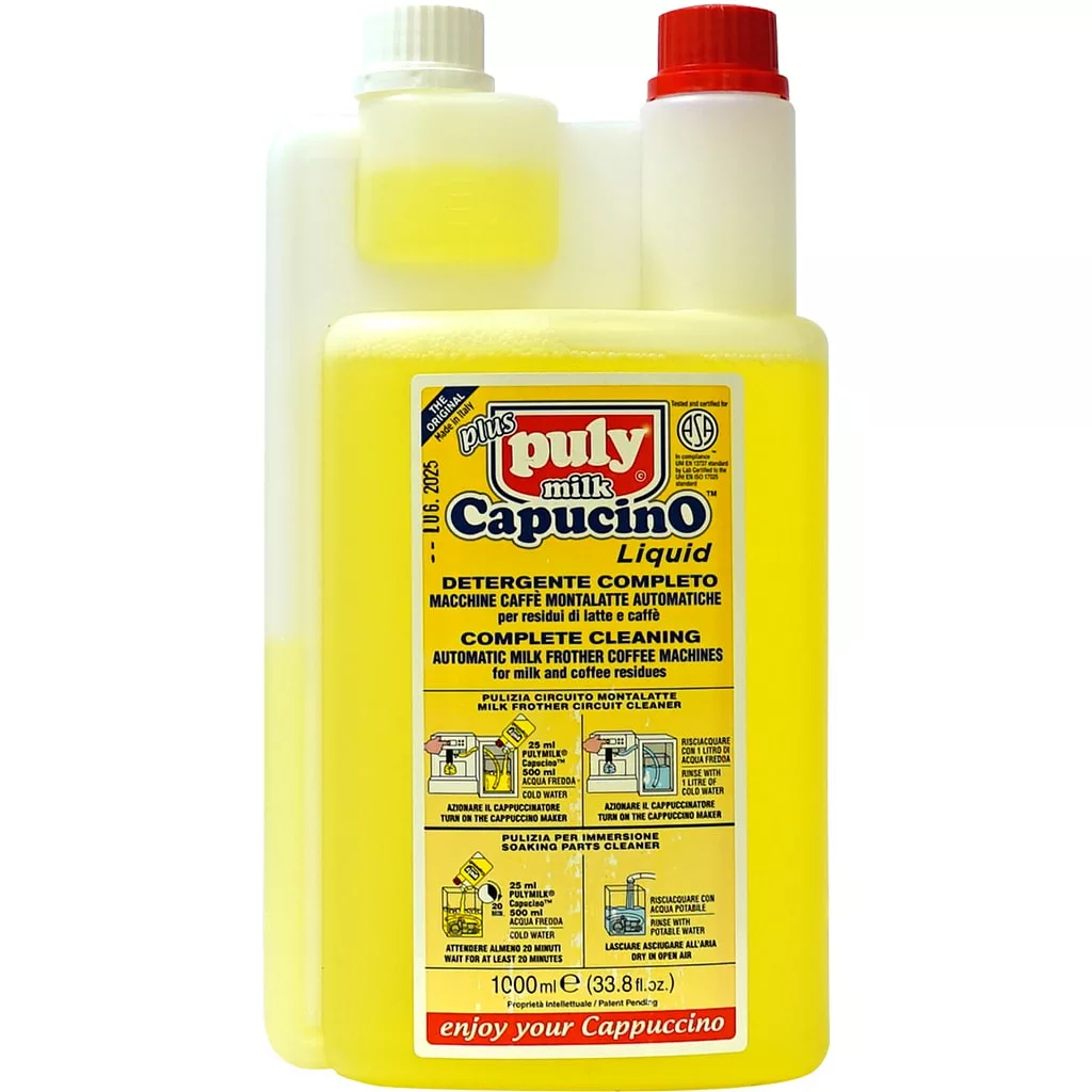 A yellow 1LT bottle of Puly Capucino Complete Detergent for automatic milk frother coffee machines, with a white measuring chamber and a multilingual label. © 2025 1st-line.com