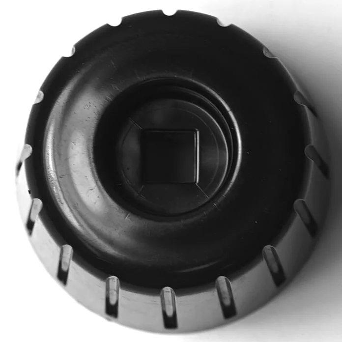 Close-up of a DISCONTINUED SM.239 COPPER GASKET 22x17x1.5mm—black, circular with a ridged edge and square center hole—photographed against a white background. © 2025 1st-line.com