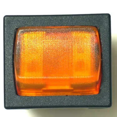 Close-up of a G..568 250V KB SWITCH, a rectangular orange rocker switch with a black frame, viewed from above. Its textured, translucent surface lets light pass through and is rated for 250V use. © 2025 1st-line.com