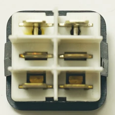 Close-up of a six-pin electrical connector with white plastic housing and gold-colored contacts in two rows, viewed from the front, typically used with the V.4411 GREEN DOUBLE SWITCH. © 2025 1st-line.com