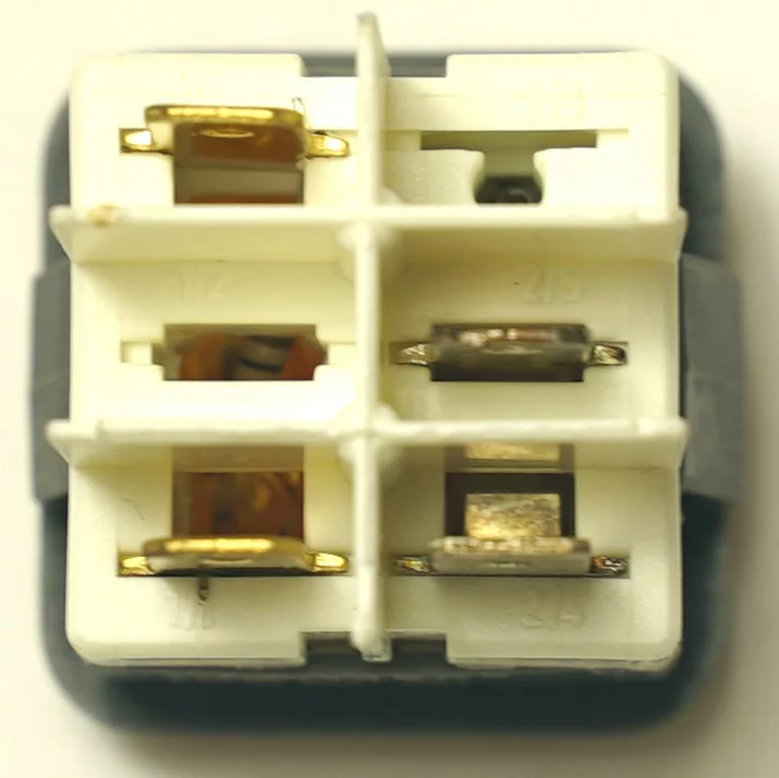Close-up of a white, rectangular V.4418 INDICATOR LIGHT connector with four metal terminals in a 2x2 grid and plastic casing, typically used for indicator light connections, viewed from the top. © 2025 1st-line.com
