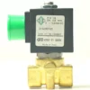 Close-up of the V.1465 230Vac 8W 1/8x1/8 ODE Solenoid, a 2-way valve with green cap and brass base. The label details model, specs, voltage, and origin (Italy). Ideal for controlling fluid or gas flow. © 2025 1st-line.com