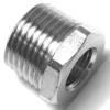 Close-up of the V.1604 1/2Mx1/4F FITTING, featuring shiny metal, outer male threads, a hexagonal head, and a central smaller female threaded hole. © 2025 1st-line.com