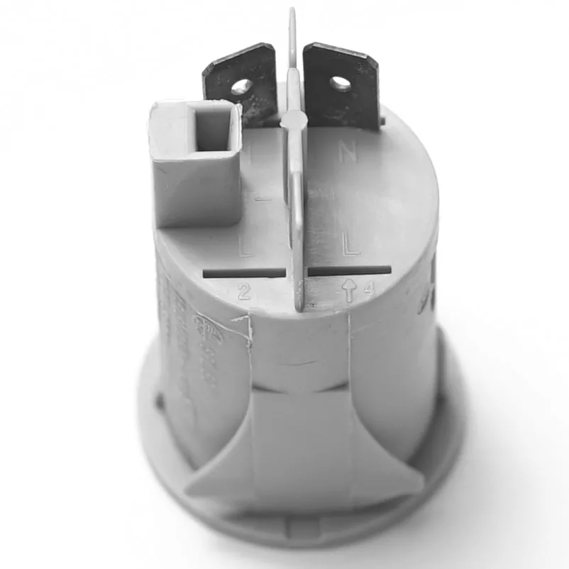 Close-up of the V.4239 PUSH SWITCH - GREY, showing two metal prongs on top, a rectangular plastic body, and surface markings labeled “L,” “N,” and “2.”. © 2025 1st-line.com