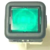 Close-up of the V.4401 MOMENTARY ROCKER SWITCH - CLEAR, a green illuminated square switch with a black border, commonly used in electronic devices or control panels for momentary on/off function. © 2025 1st-line.com