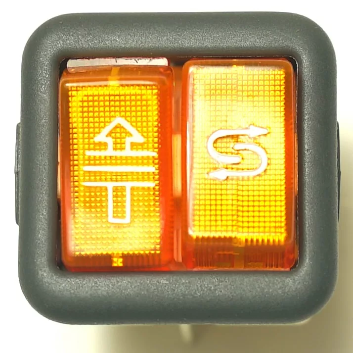 Close-up of the V.4418 INDICATOR LIGHT: a rectangular, black-framed switch with orange illumination, two buttons featuring a white up arrow with lines on the left and an S with arrows on the right, plus a bright indicator light. © 2025 1st-line.com