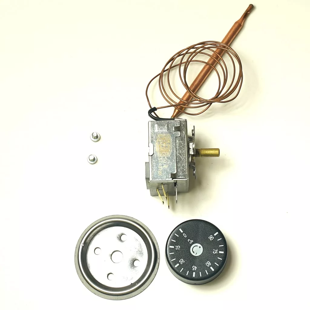 The J....0 0-90D C Thermostat for milk warmer features a control knob, metal capillary tube, round plate, two screws, and a rectangular thermostat unit, all shown on a white background. © 2025 1st-line.com