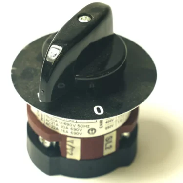 The Mazzer S000INA09 Two Pole Rotative Switch has a black handle set to 0, mounted on a circular base with voltage and current ratings labeled around the edge. © 2025 1st-line.com